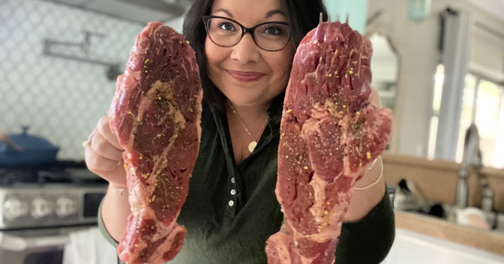 woman holding up butcher box steak