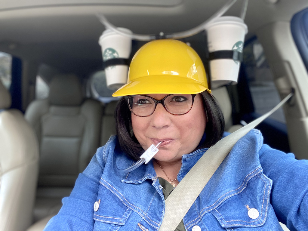 woman in car drinking out of hands-free helmet