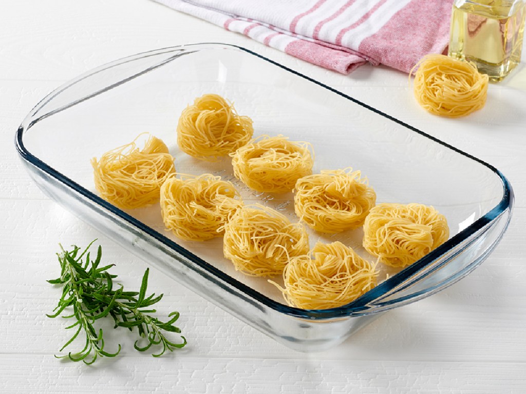 glass baking dish filled with pasta circles on counter