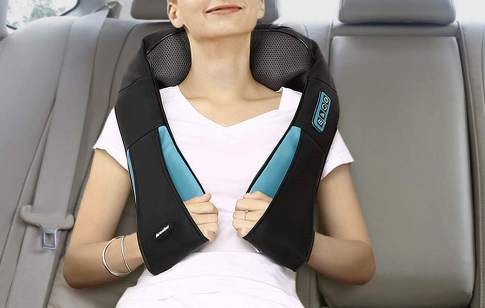 woman sitting in a car using a neck massager