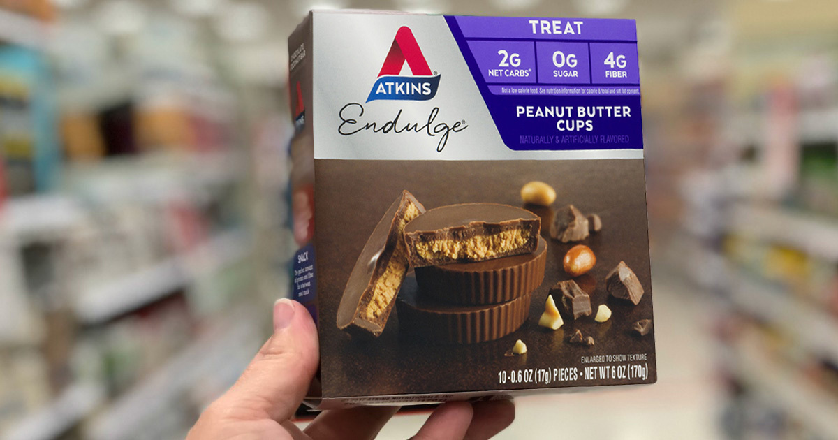 hand holding a box of Atkins peanut butter cups