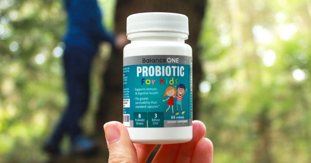 person holding up bottle of balance one kids probiotic