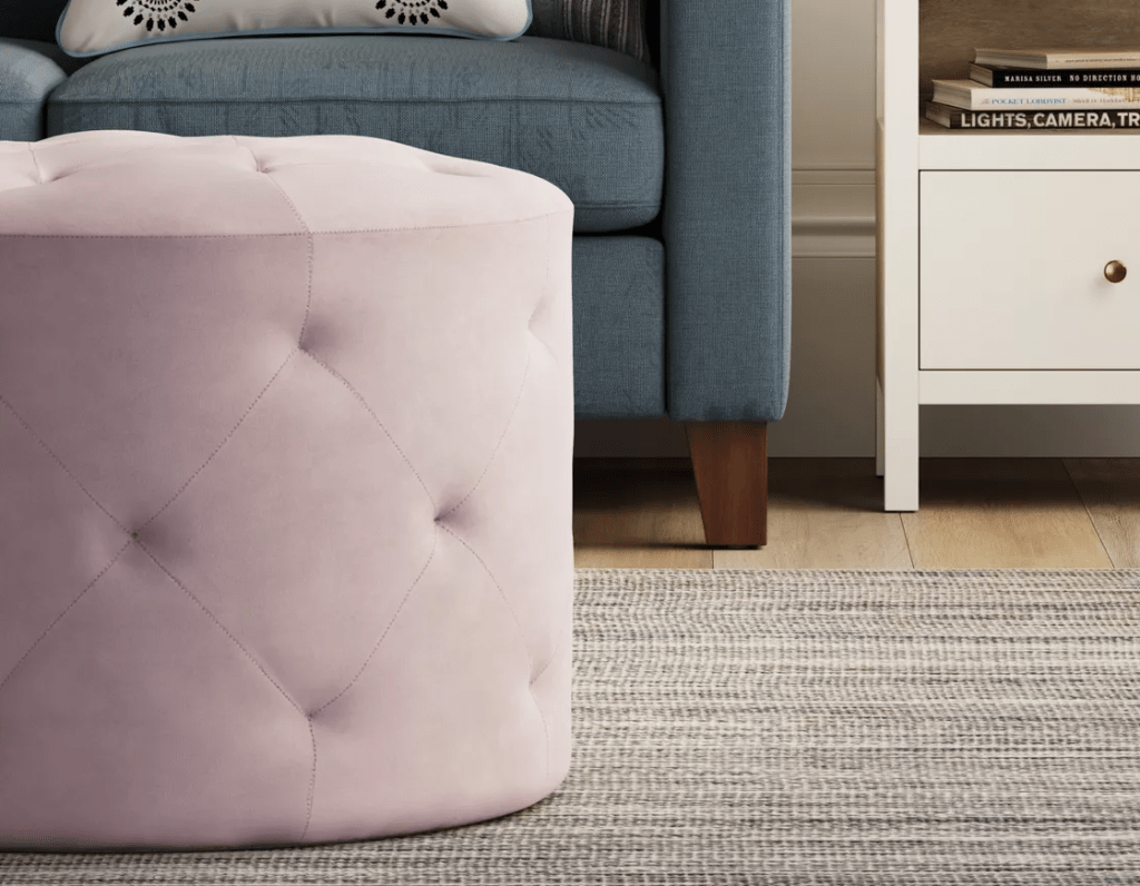 pink ottoman by a couch