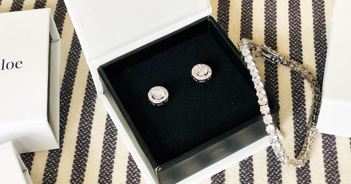 pair of earrings in black jewelry box with bracelet beside it