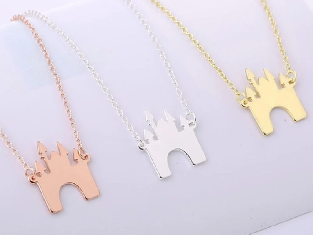 hand holding castle necklaces