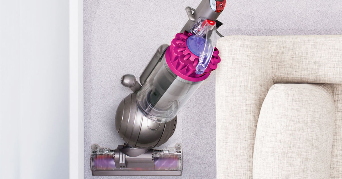 pink and grey dyson vacuuming around a couch