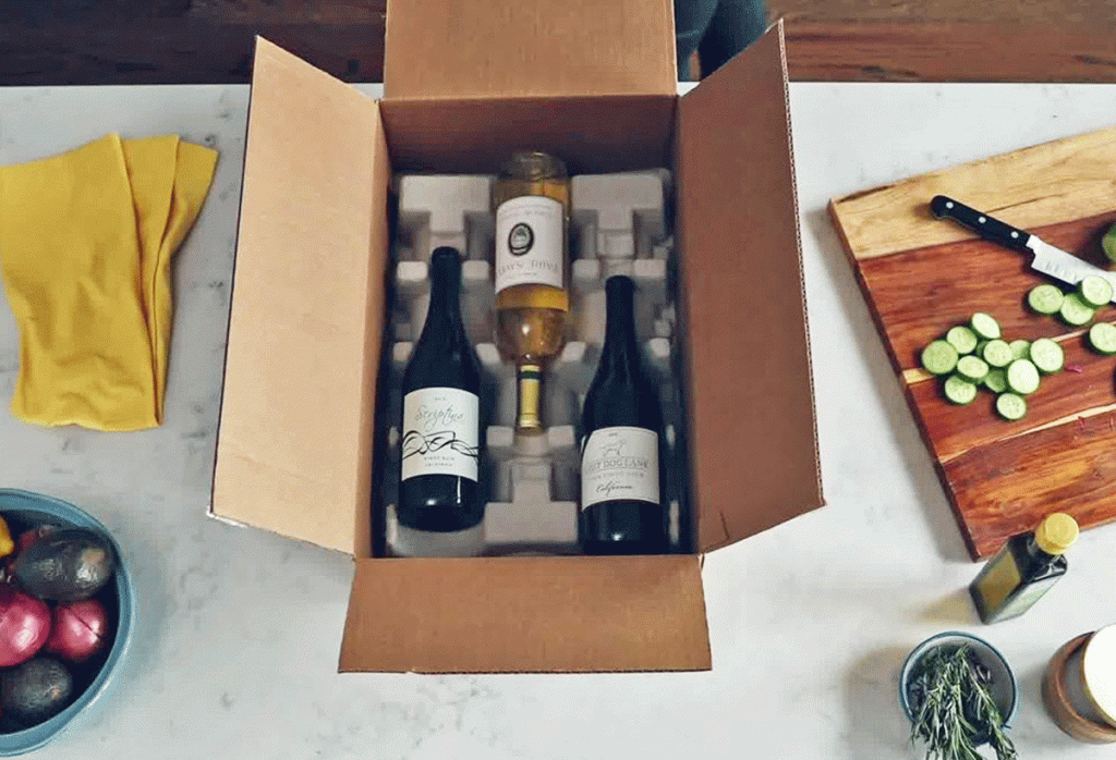 three bottles of wine in shipping box on kitchen counter