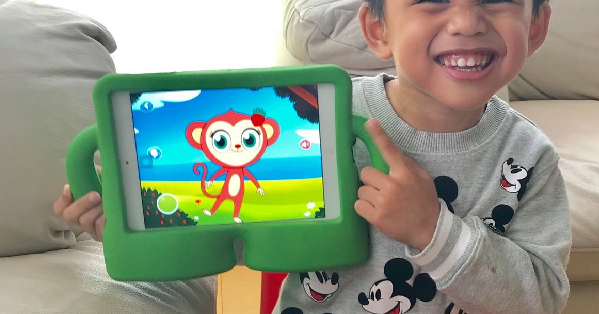 Young boy holding a tablet with an educational game
