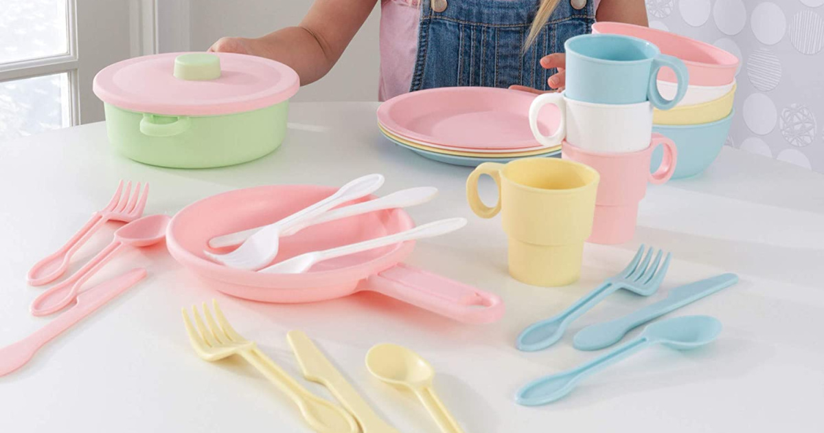 kids pastel plastic play dishes set spread out on a table in front of a young child