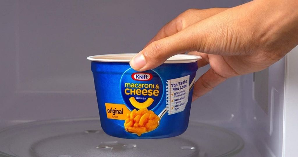 hand putting Kraft mac & cheese in microwave