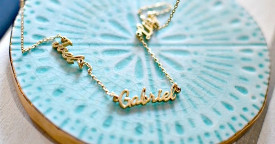 name necklace on a blue dish