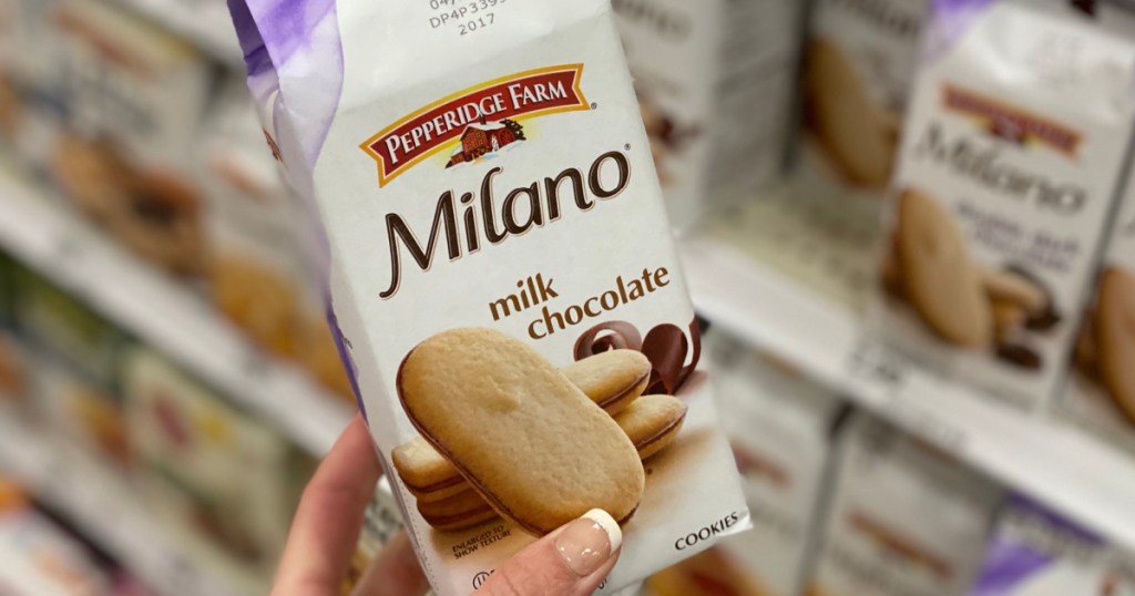 Hand holding a bag of milano cookies