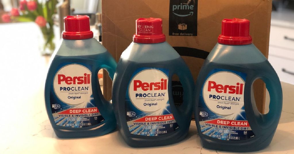 3 bottles of Persil Detergent on counter in front of Amazon box