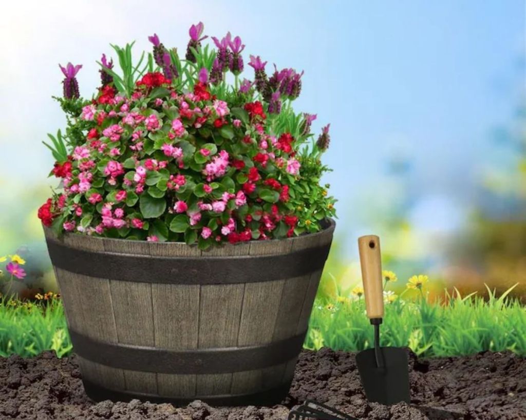 Style flowers planted in Selections Oak Resin Barrel Planter outside with trowel