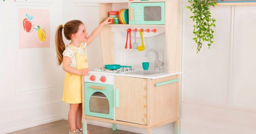 girl playing with kitchen set