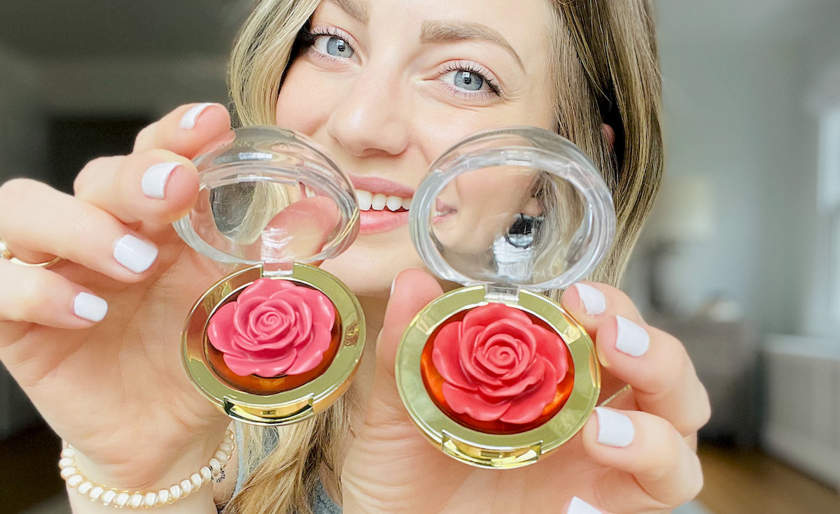 woman holding two rose shaped makeup blushes
