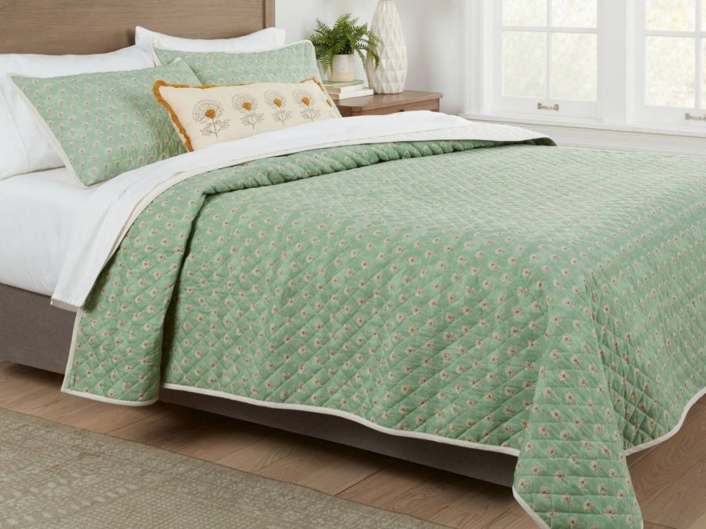 Green quilt bedding on bed