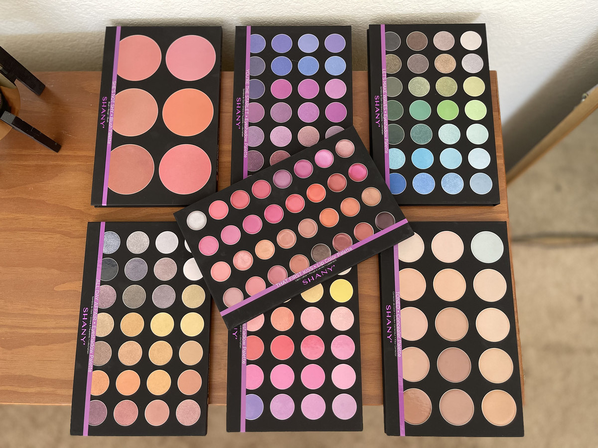 various colorful shany cosmetics makeup palette spread out on top of wood dresser
