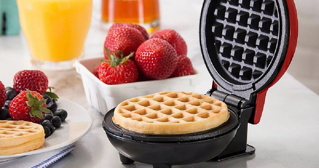 red dash mini waffle maker with waffle in it