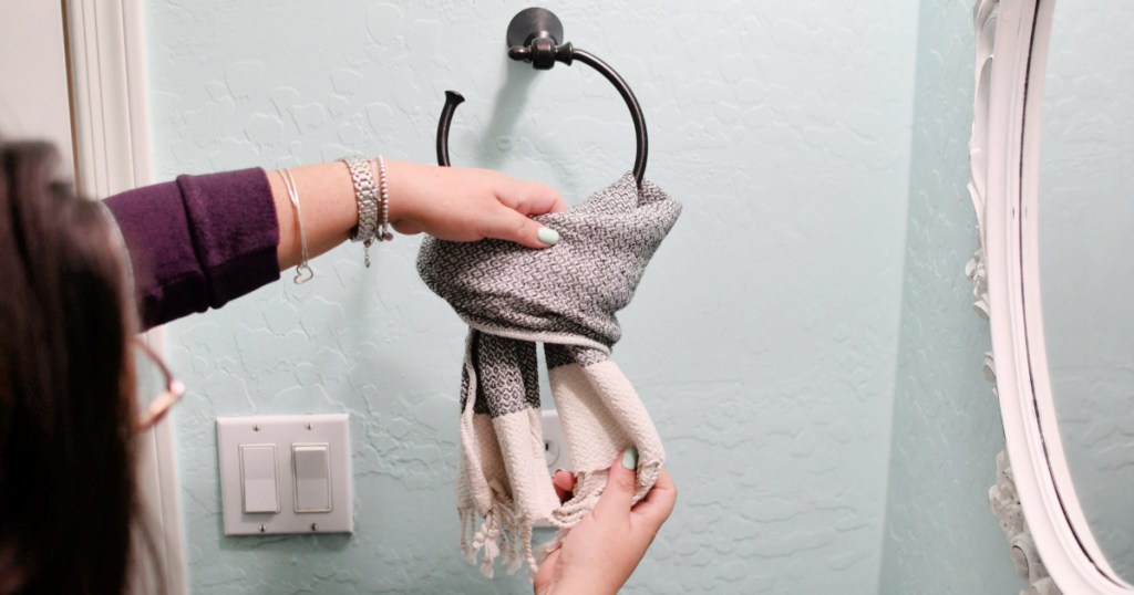 demostrating how to hang a hand towel