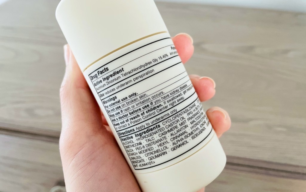 hand holding deodorant stick with ingredients label showing