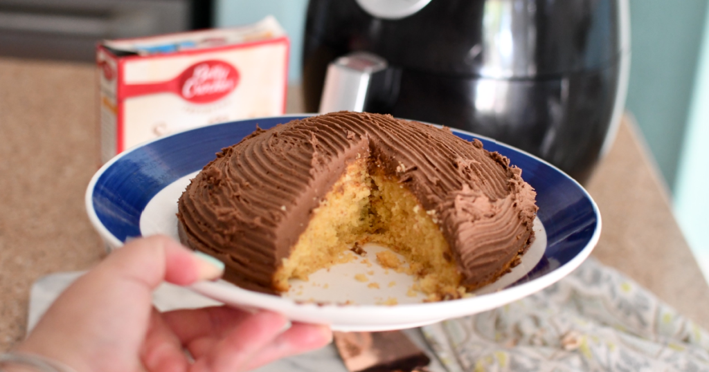 holding chocolate air fryer cake with slice missing