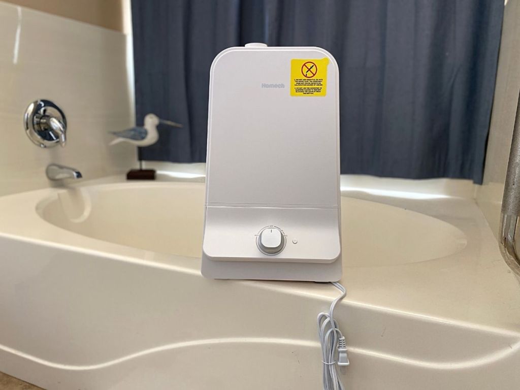 white humidifier sitting on side of whirlpool tub