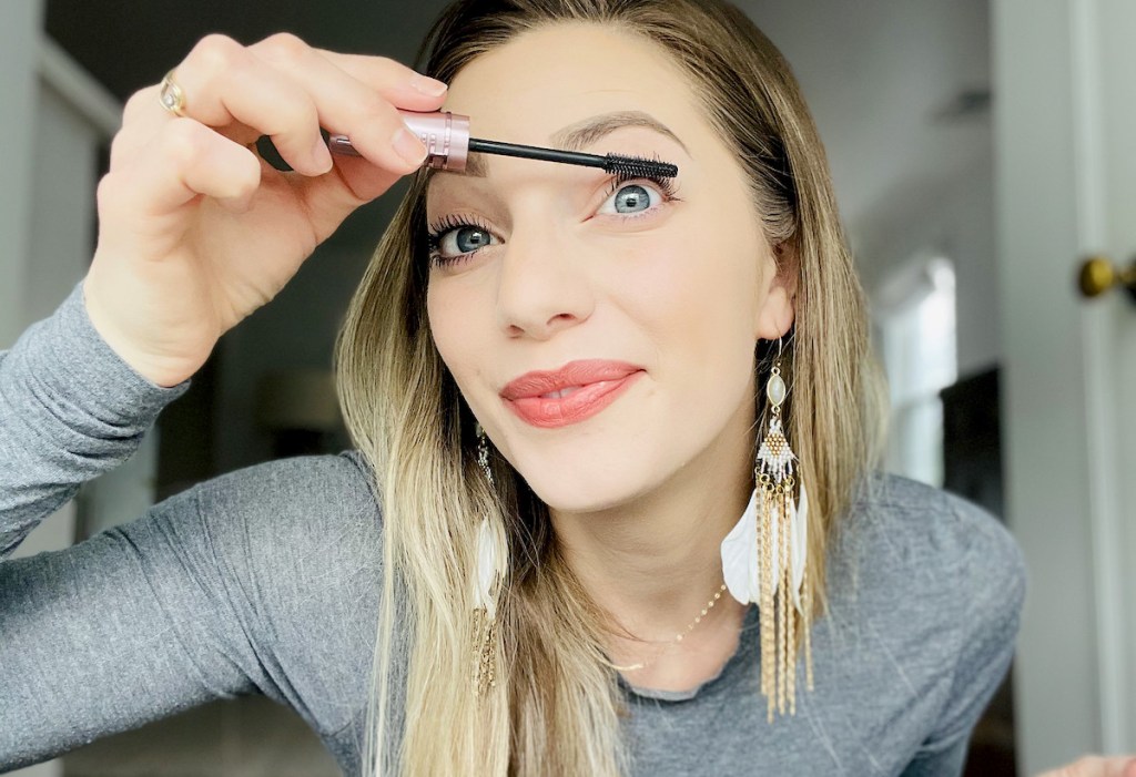 woman putting on maybelline sky high mascara