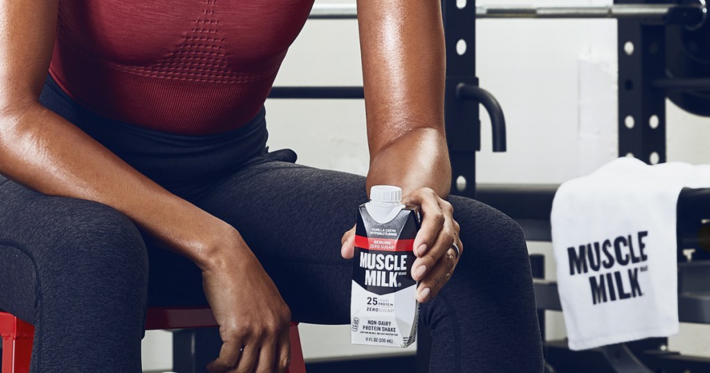 muscle milk in hand of woman at gym