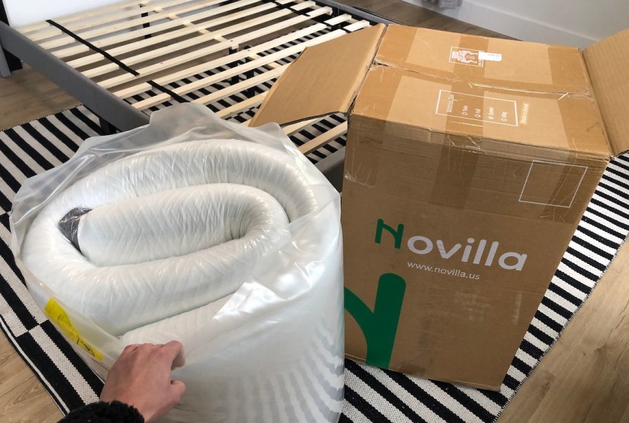 hand holding rolled up mattress in bag