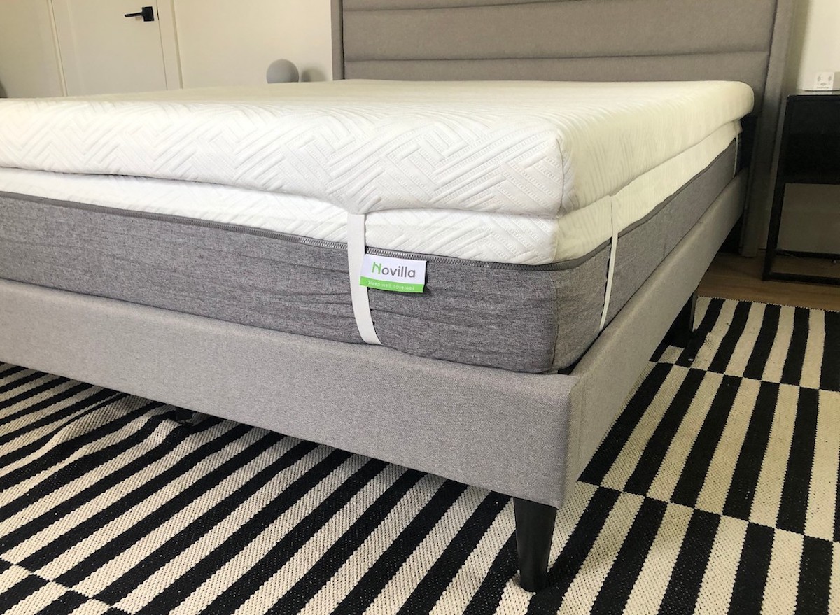 close up of mattress on gray upholstered bedframe