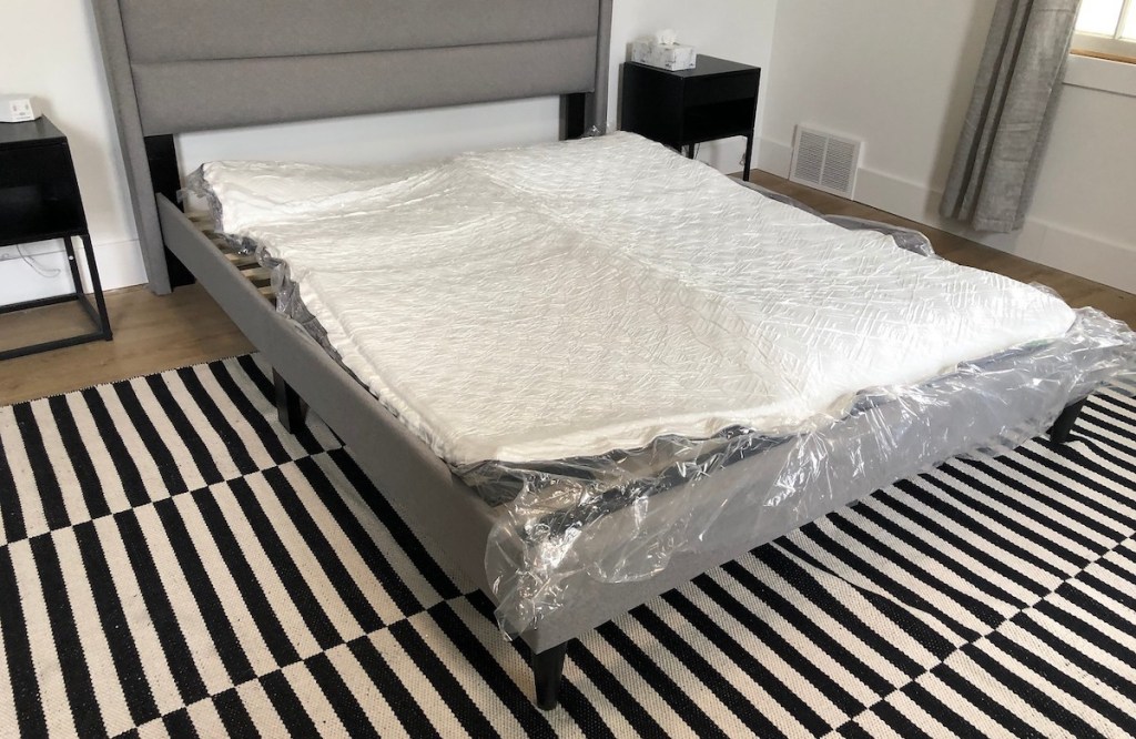 unrolled mattress on bedframe