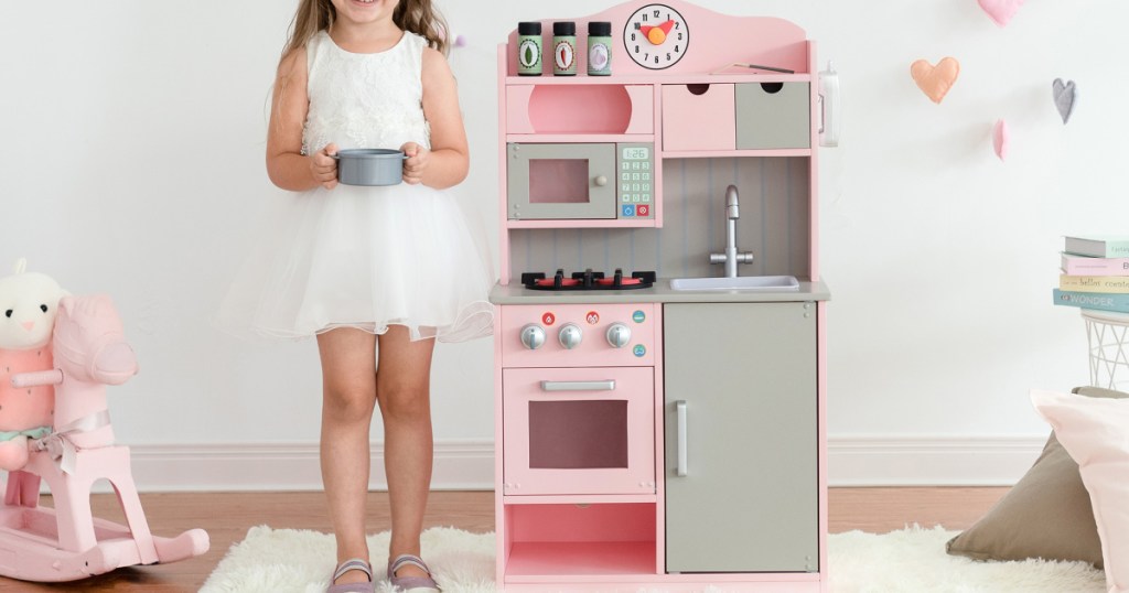 pink play kitchen with little girl
