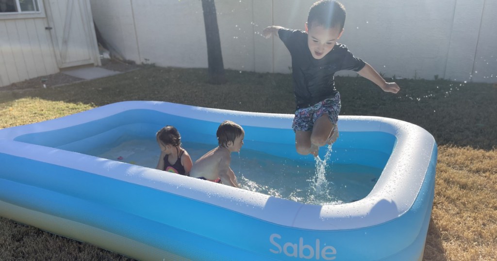boy jumping in sable inflatable pool