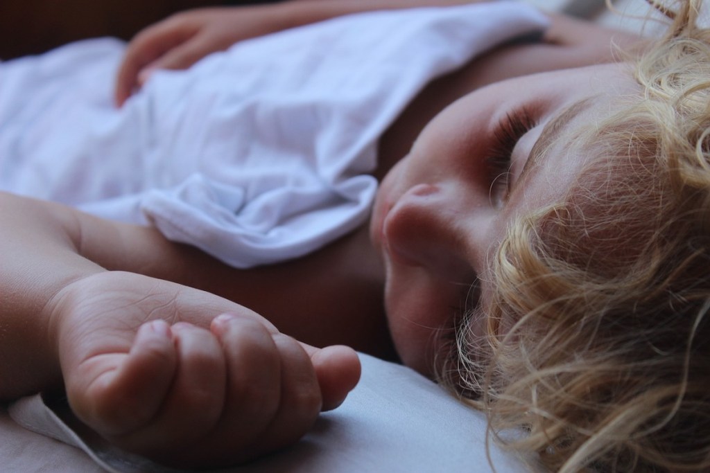 close up of sleeping child in bed babysitting rates