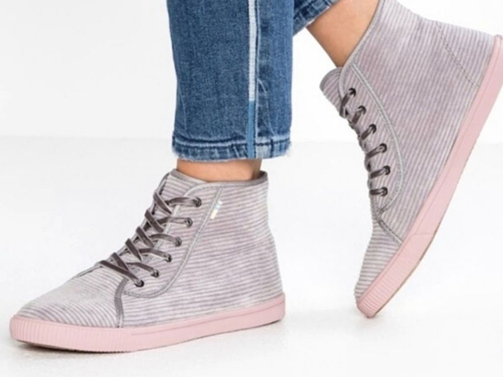 lower view of woman wearing skinny jeans and gray striped high tops with pink soles
