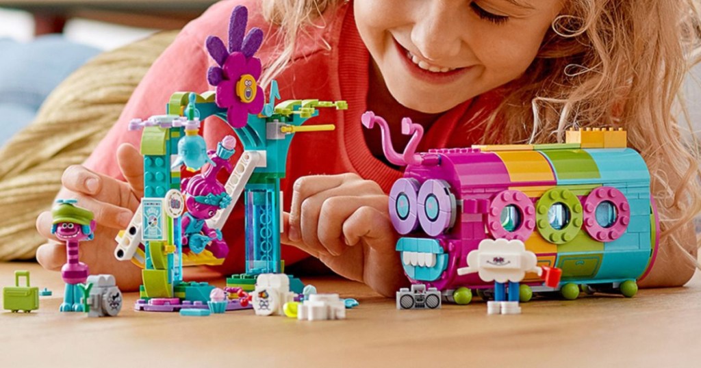 girl playing with trolls lego bus