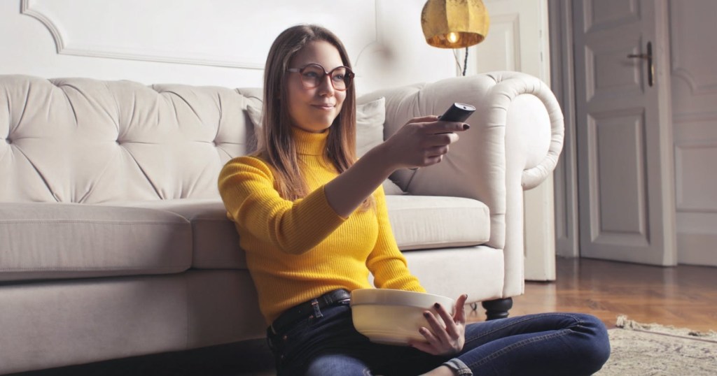 woman holding popcorn and TV remote