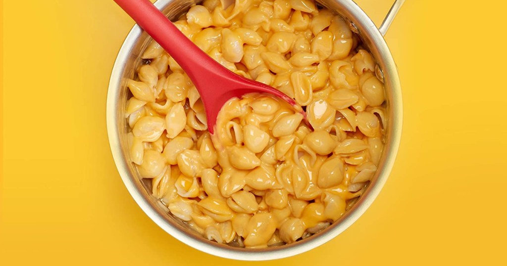 macaroni and cheese in a pot with a red spoon