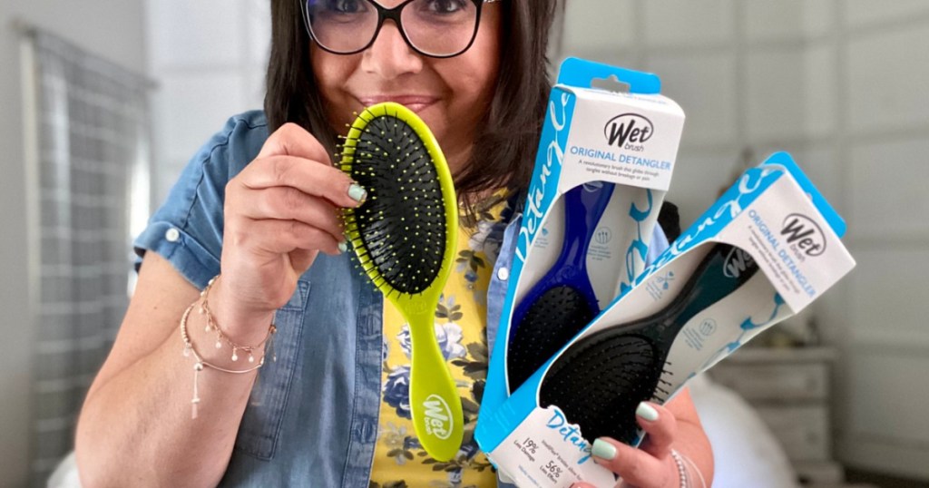 woman holding 3 different wet brushes