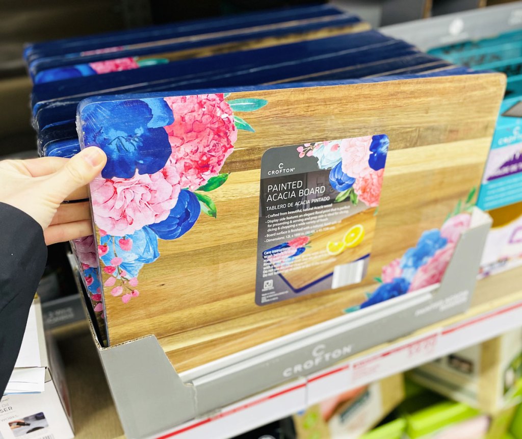 woman holding a floral cutting board on shelf at aldi