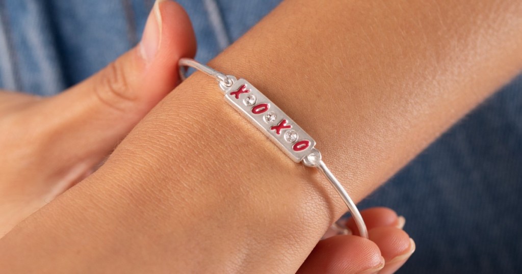 Woman wearing an XOXO themed charm bracelet