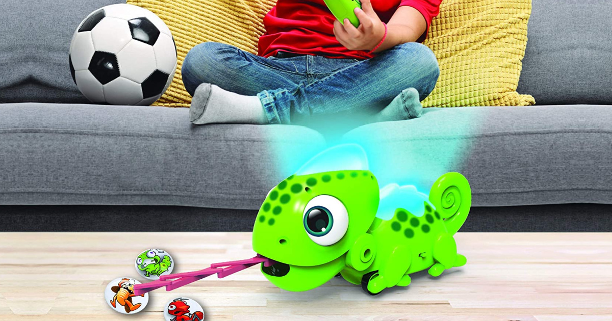 boy sitting on couth next to soccer ball behind robotic chameleon toy