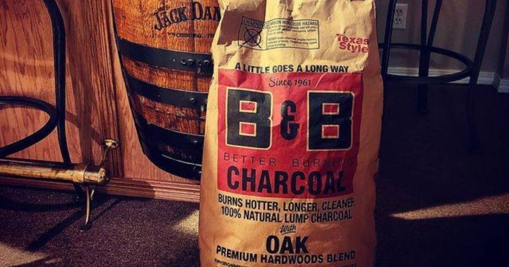 B&B Charcoal Oak Hardwood Lump Charcoal 20-lb Bag in front of Jack Daniels Barrel