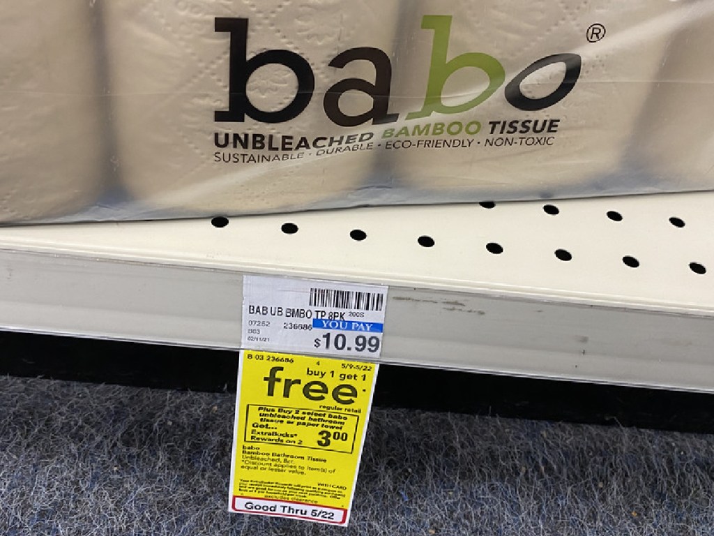 pack of toilet paper and sale sign on store shelf