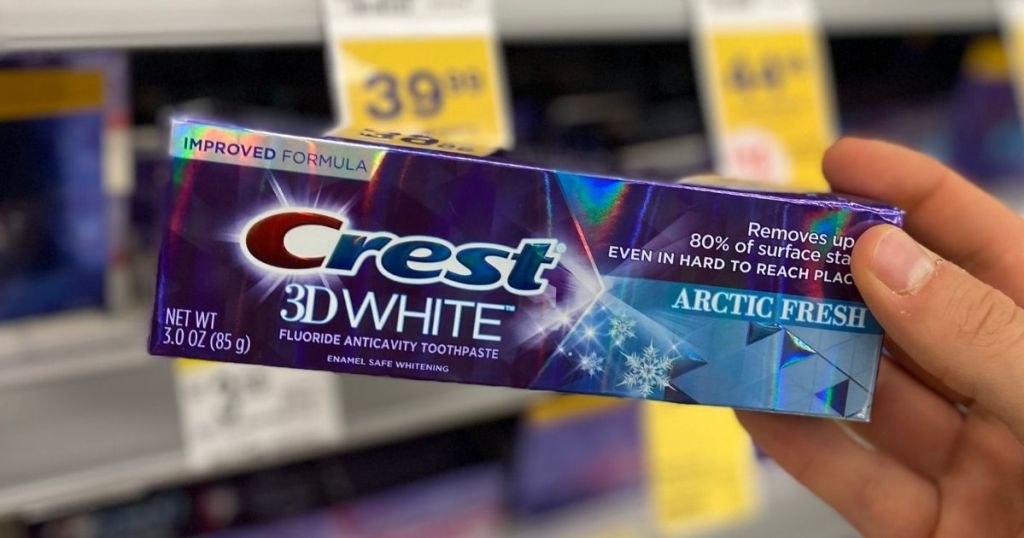 hand holding a package of Crest 3D White
