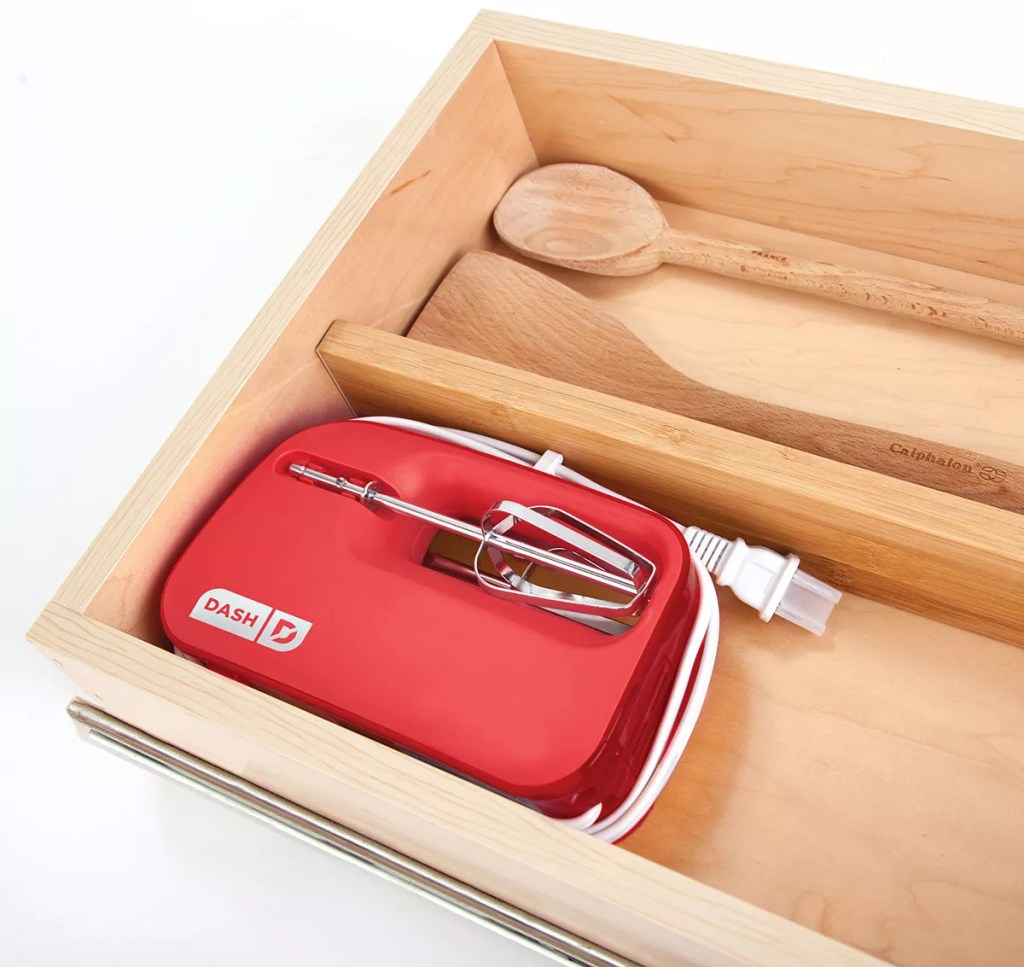 small red hand mixer in drawer
