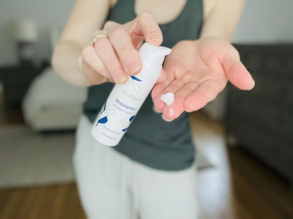 hand holding a bottle of moisturizer