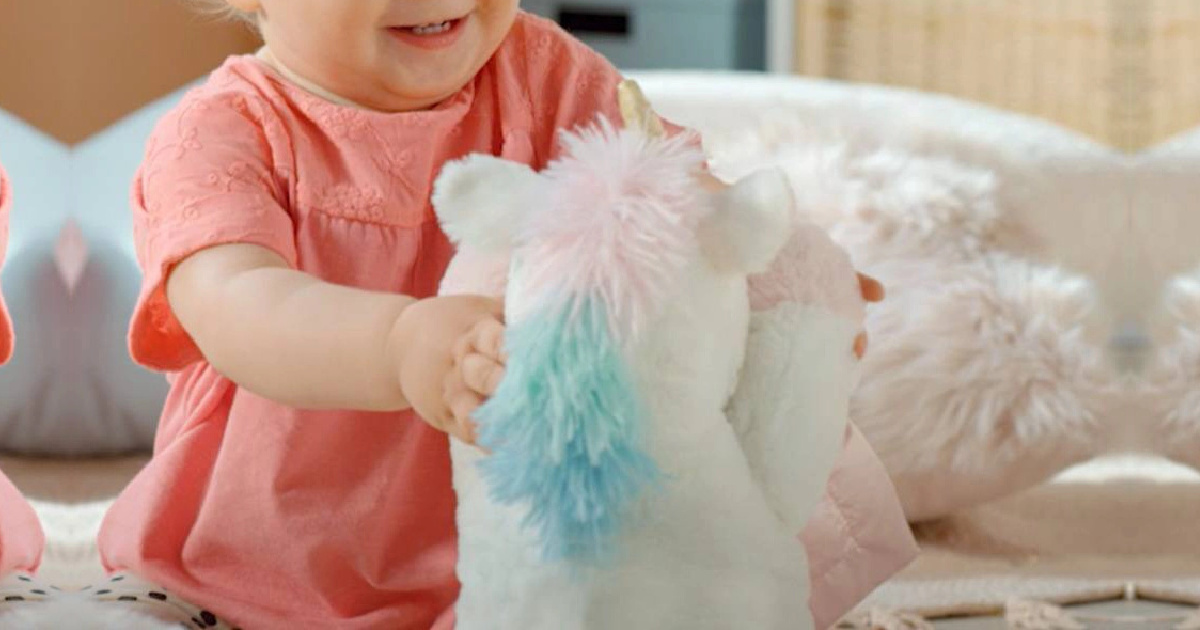baby holding a unicorn plush
