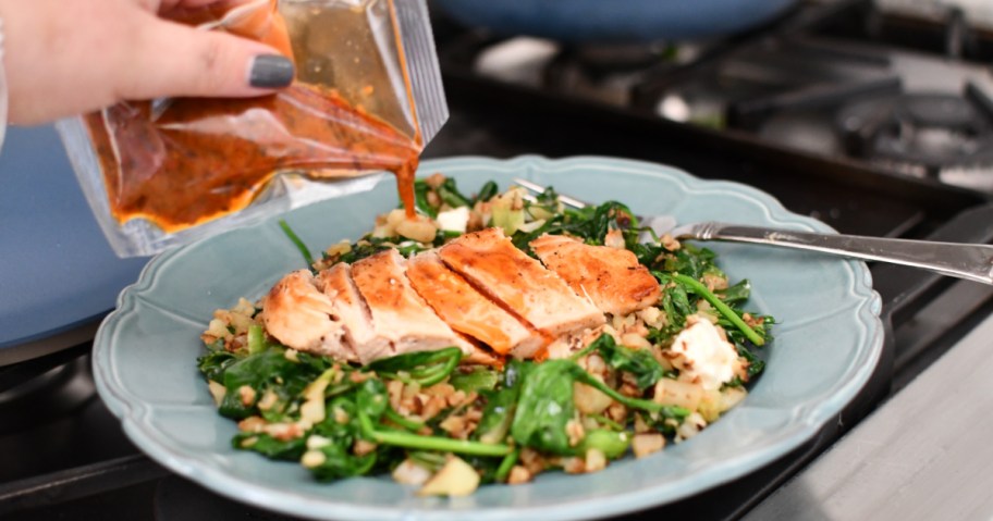hand pouring dressing on chicken salad